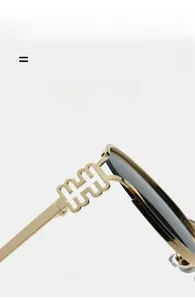 Close-up of golden metal temple and H-shaped decorative detail on round sunglasses