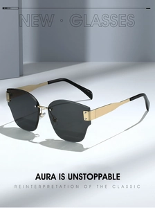 Detail shot of frameless sunglasses featuring gold metal temples and dark gray resin lenses