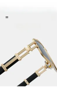 Detail view of premium golden metal hinge on lightweight black punk sunglasses