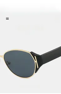 Detail of cat-eye sunglasses featuring golden frame and black temples with K-shaped accent
