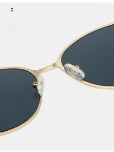 Detailed macro of gold metal bridge and soft nose pads on retro cat eye sunglasses