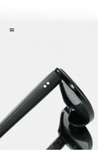 Detail shot of black glossy sunglasses frame featuring silver double dot metal accents