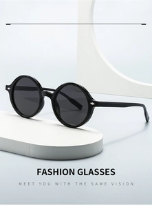 Gros plan sur des lunettes de soleil ovales noires rétro avec détails en argent et socle