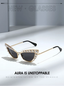 Close-up of golden cat-eye sunglasses with luxury pearl embellishments on frame