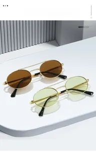 Detail view of gold metal double bridge oval sunglasses with brown resin lenses