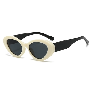 Occhiali da sole retrò cat-eye con montatura crema e stanghette nere su sfondo bianco