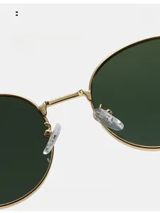 Détail macro des plaquettes de nez en silicone et du pont métallique doré des lunettes