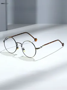 Detailed close-up of retro round metal frame glasses with tortoise temple tips and specs