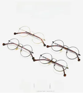 Detail view of round metal eyeglass frames in black and gold with tortoiseshell temples