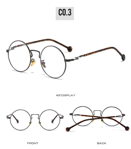 Detail view of round metal glasses with tortoiseshell temples and golden nose pads