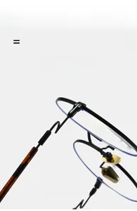 Detail of round metal glasses frame featuring golden nose pads and tortoiseshell temple tips