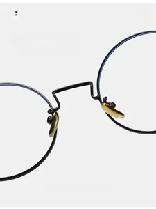 Close-up of golden metal nose pads on black round frames for comfortable long-term wear