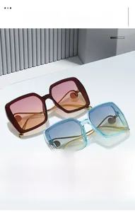 Détail de lunettes de soleil carrées oversize avec verres dégradés sur socle géométrique