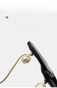 Détail de lunettes de soleil de luxe avec monture noire, branches dorées et perles