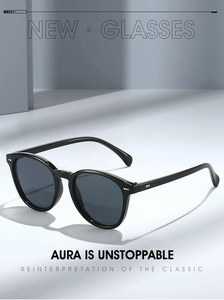 Macro shot of oval black sunglasses with silver stud accents and dark tinted lenses