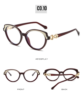 Detail view of reddish brown cat-eye glasses with golden decorative temple hinges