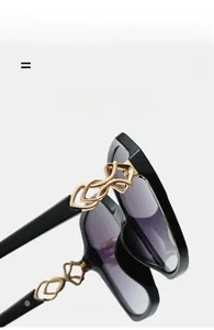 Detail of square sunglasses with gold metal hinges and purple gradient lenses