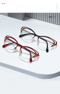 Detail of cat-eye semi-rimless hollow metal frames in wine red and black bicolor