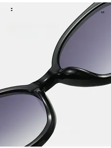 Detail of trendy oval sunglasses featuring gradient purple lenses and smooth black frames