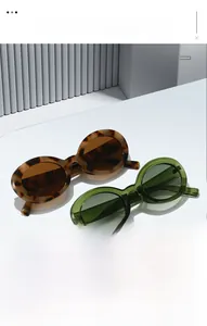 Close-up of retro oval sunglasses in tortoiseshell and olive green frames with lenses