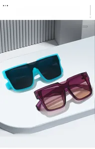 Detail of square oversized sunglasses in blue and purple frames on a minimalist display