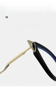 Close-up of cat-eye glasses frame featuring a golden metal hinge with triangular detail