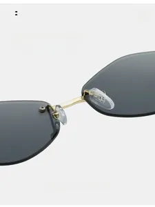 Detailed close-up of golden metal bridge and soft nose pads on rimless sunglasses