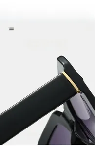Close-up of golden hinges and flexible black arms on square frame sunglasses