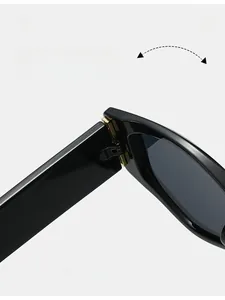 Détail de la charnière en métal doré sur la monture noire de lunettes de soleil