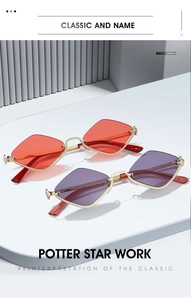Close-up of geometric gold metal frame sunglasses with red and purple lenses on a pedestal