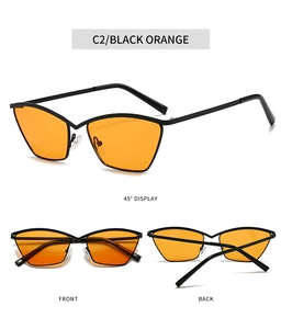Detail view of cat eye sunglasses with black metal frames and vibrant orange lenses