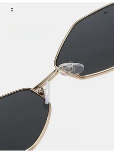 Détail des plaquettes de nez en silicone sur lunettes de soleil géométriques dorées
