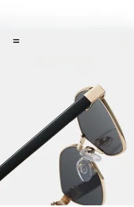 Detail of lightweight golden metal hinges and black temples on polygon sunglasses