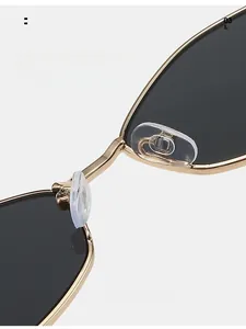Detail of ergonomic transparent silicone nose pads on gold metal sunglasses frame
