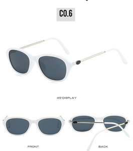 Detail view of white cat-eye sunglasses with dark grey lenses and golden metal temples