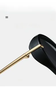 Detail of sunglasses featuring super elastic gold metal hinges and black frame
