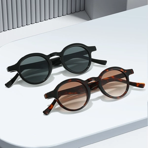 Retro oval sunglasses in classic black and tortoiseshell finish on geometric surface