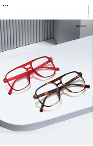 Detail of square pilot glasses frames in translucent red and tortoiseshell patterns