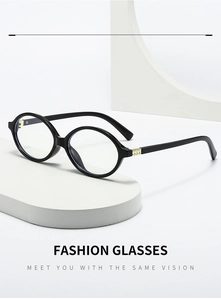 Detail of oval black frames with gold metal studs on a minimalist white display stand