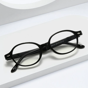 Modern black oval TR frame blue light blocking glasses shown on a white geometric stand