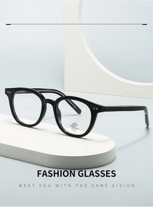 Detail of classic black oval frame glasses with metal accents on a geometric base