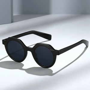 Retro-Sonnenbrille mit schwarzem geometrischem Rahmen und dunklen Gläsern im Studio