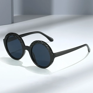 Retro round frame sunglasses with black engraved frame and blue lenses from a side view