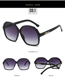 Macro detail of oval sunglasses frame with gold logo and purple gradient lenses