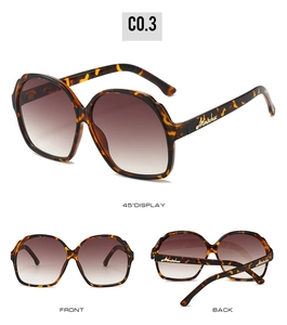 Detail view of oval leopard frame sunglasses with gradient lenses and gold temple logos
