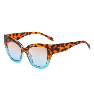 Retro cat-eye sunglasses with tortoiseshell and blue gradient lenses on white background