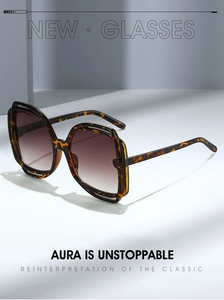 Detail of oversized tortoiseshell sunglasses with double-layered frame and brown gradient lenses