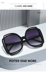 Detail of trendy hollow-frame sunglasses with purple gradient lenses on a blue stand