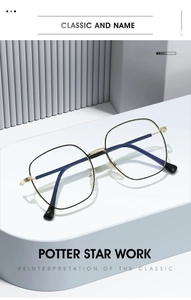 Detail view of large square black and gold metal eyeglass frames on a minimalist pedestal
