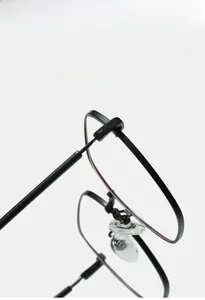 Close-up of lightweight metal glasses frame with flexible hinges and soft silicone nose pads